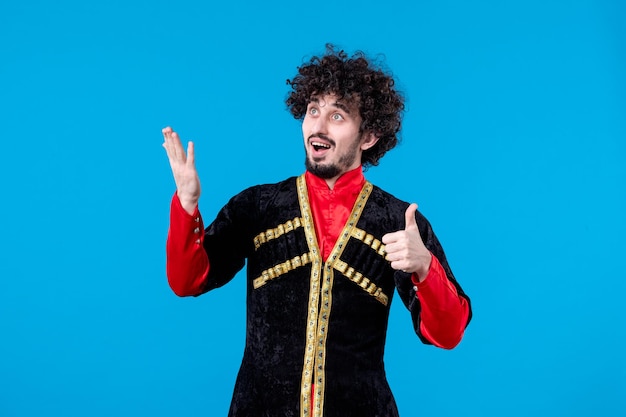 Retrato de homem azeri animado em estúdio de traje tradicional atirou em fundo azul dançarina étnica novruz