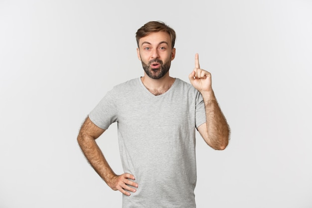 Retrato de homem barbudo bonito em camiseta cinza