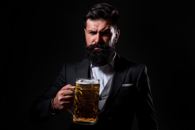 Retrato de homem barbudo sério, bebendo cerveja. Cervejeiro feliz segurando o copo com cerveja.