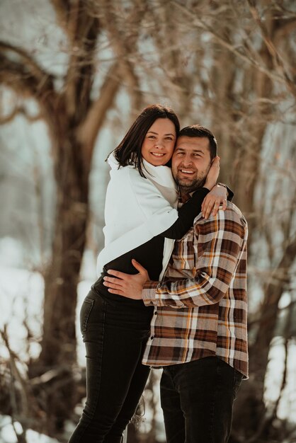 Retrato de homem bonito abraçando sua amada esposa em um dia de inverno Foco seletivo