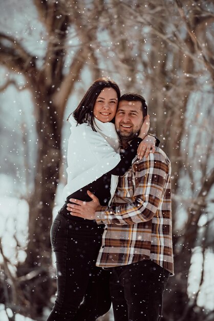 Retrato de homem bonito abraçando sua amada esposa em um dia de inverno Foco seletivo