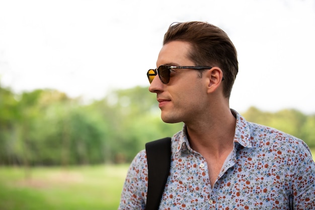 Retrato de homem bonito alegre com óculos de sol.