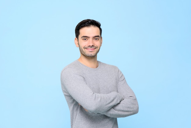 Retrato de homem bonito amigável sorridente em camiseta cinza lisa com os braços cruzados isolado na luz