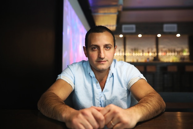 Retrato de homem bonito armênio fumando narguilé em um café