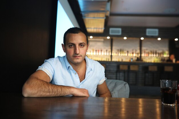 Retrato de homem bonito armênio fumando narguilé em um café