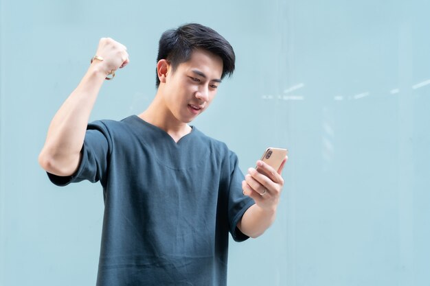 Retrato de homem bonito asiático segurando um smartphone