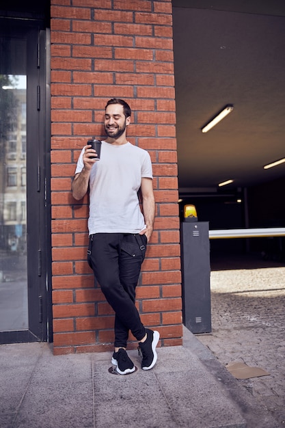 Retrato de homem bonito com café olhando para longe