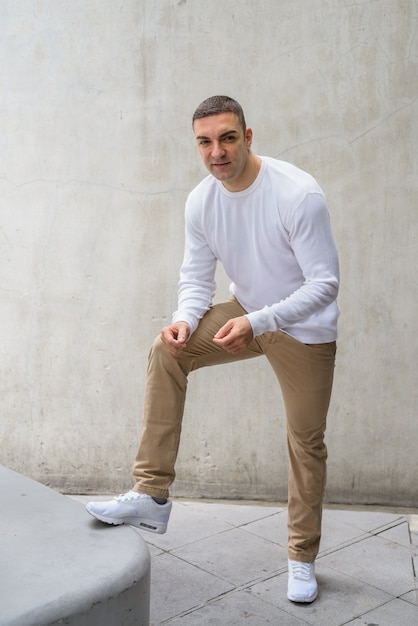 Retrato de homem bonito contra uma parede de concreto ao ar livre