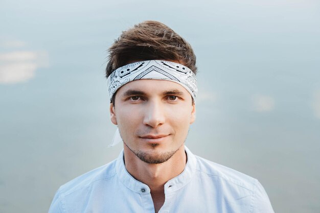 Retrato de homem bonito em reflexo de água de fundo de céu azul