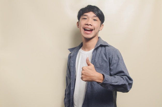 Retrato de homem bonito na camisa cinza, mostrando expressão ok