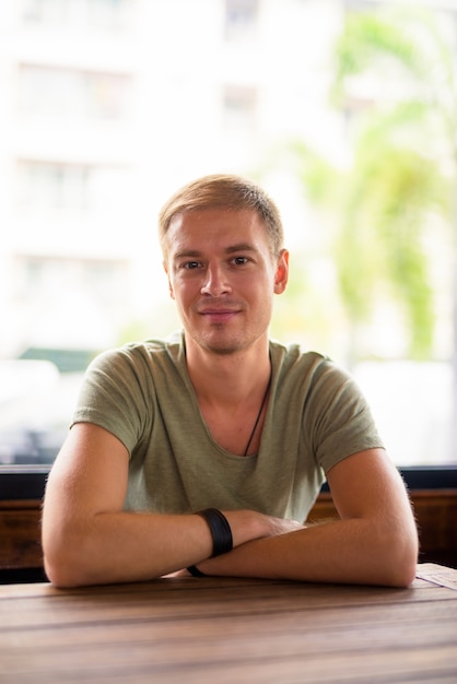 Foto retrato de homem bonito relaxando na cafeteria