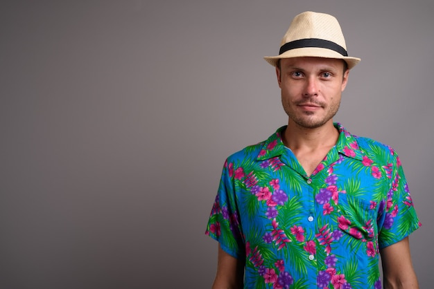 Foto retrato de homem bonito turista com chapéu pronto para as férias em cinza