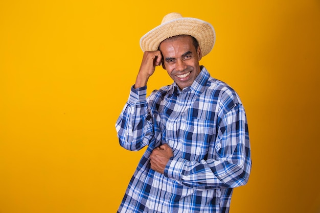 Retrato de homem brasileiro vestindo roupas típicas para a Festa JuninaxA