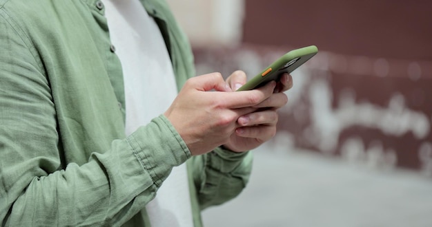 Retrato de homem casual de óculos usando smartphone na rua Homem barbudo bonito digitando mensagens no telefone fora Mensagens online e navegação na internet