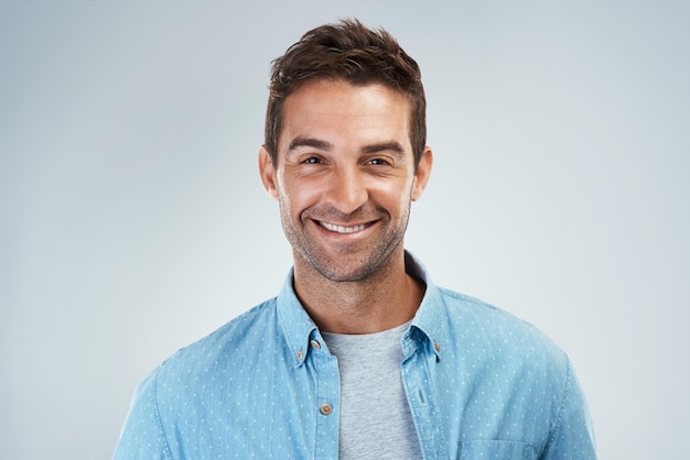 Retrato de homem casual e feliz com moda em estúdio ou roupa de moda para confiança em fundo branco Modelo de pessoa masculina positiva ou criativa com sorriso orgulhoso roupas ou estilo moderno para relaxar