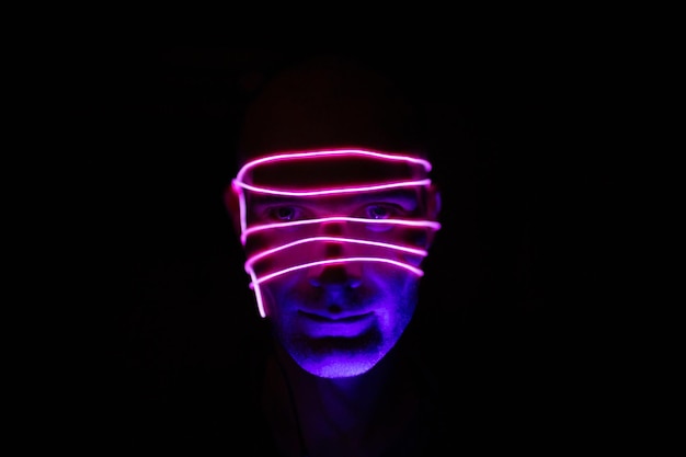 Retrato de homem com linhas de brilho neon em seu rosto Conceito cyberpunk e realidade virtual