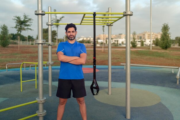 Retrato de homem confiante fazendo exercícios de fitness em um dispositivo de suspensão especial