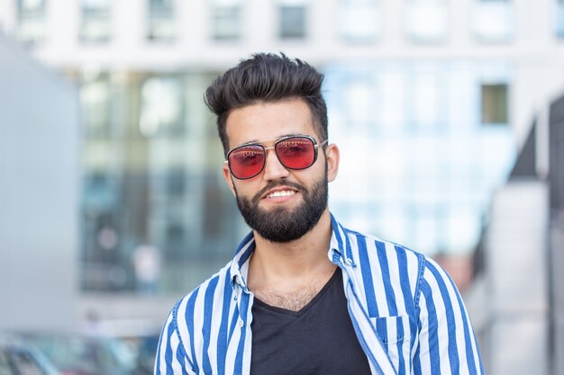 Retrato de homem de confiança bonito com uma barba ao ar livre.