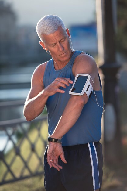 retrato de homem de corrida sênior bonito enquanto relaxa e faz uma pausa após a corrida matinal