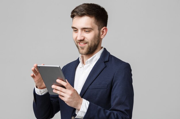 Retrato de homem de negócios bonito jogando tablet digital com um rosto sorridente e confiante