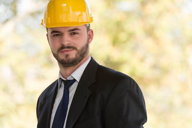 Retrato de homem de negócios com capacete amarelo na construção