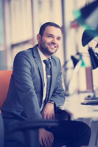 Retrato de homem de negócios jovem feliz no escritório moderno brilhante interior