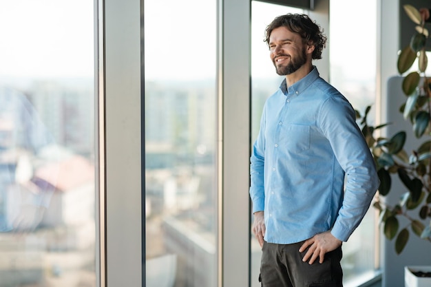 Retrato de homem de negócios sorridente, olhando para a janela