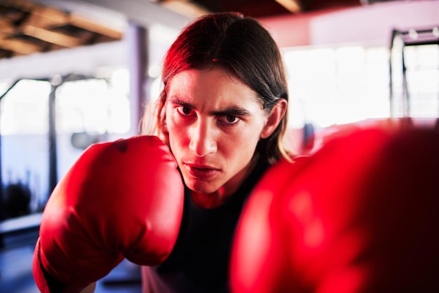 Retrato de homem e boxeador na academia para exercício de treino ou treinamento para luta Cara de esportes de boxe e soco de atleta de fitness sério para competição de desafio de mma ou exercício para poder de artes marciais