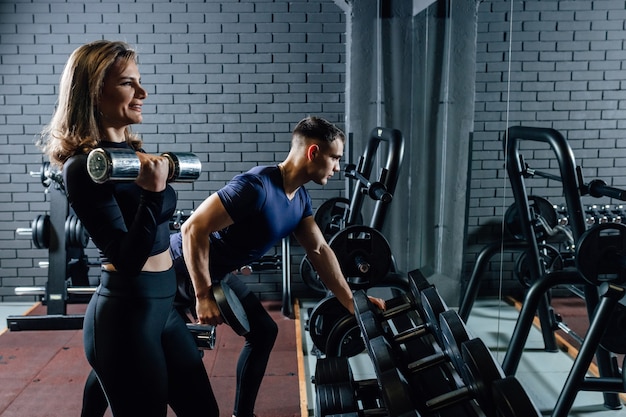 Foto retrato de homem e mulher esportivos treinando com halteres