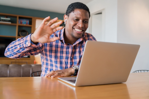 Retrato de homem em uma videochamada de trabalho com laptop de casa