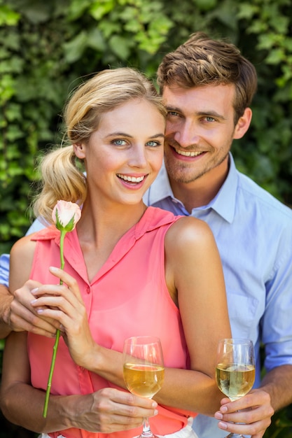 Retrato, de, homem feliz, dar flor, a, mulher, segurando, copo de vinho