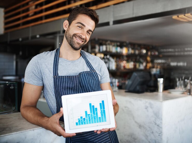 Foto retrato de homem feliz e garçom com tela de tablet para receita de lucro ou estatísticas em café pessoa masculina barista ou proprietário de negócio com sorriso para gráfico de gráfico ou tecnologia em restaurante interno