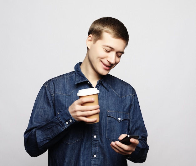 Retrato de homem feliz falando no telefone e tomando café