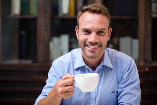 Retrato de homem feliz, segurando a xícara de café