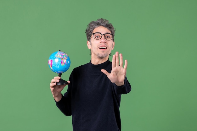 retrato de homem gênio segurando globo terra estúdio tiro fundo verde espaço professor escola natureza planeta mar ar