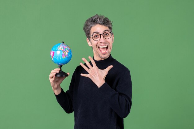 Foto retrato de homem gênio segurando globo terrestre estúdio tiro fundo verde escola ar mar espaço professor planeta