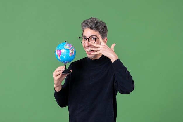 retrato de homem gênio segurando globo terrestre estúdio tiro fundo verde escola espaço aéreo professor natureza planeta