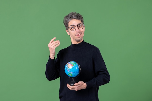 Foto retrato de homem gênio segurando globo terrestre estúdio tiro fundo verde natureza planeta ar professor espaço