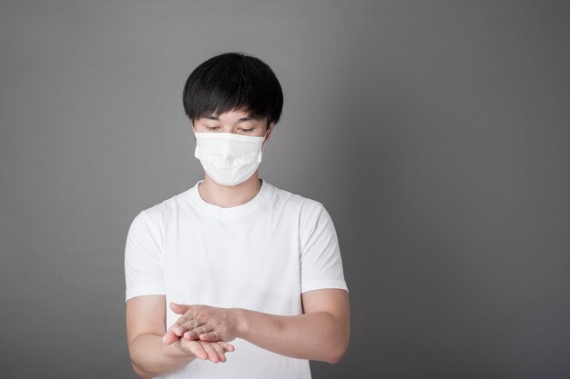 Retrato de homem higienizando as mãos com gel de álcool, conceito de cuidados de saúde