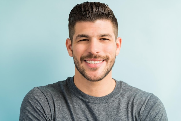 Retrato de homem hispânico atraente sorrindo em estúdio