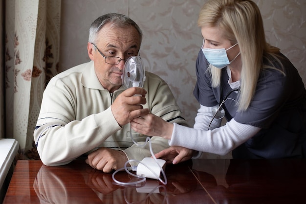 Retrato de homem idoso com inalação de gripe em casa. O homem caucasiano sênior faz inalação com uma máscara nebulizadora em casa para doença de coronavírus. Conceito de cuidados de saúde