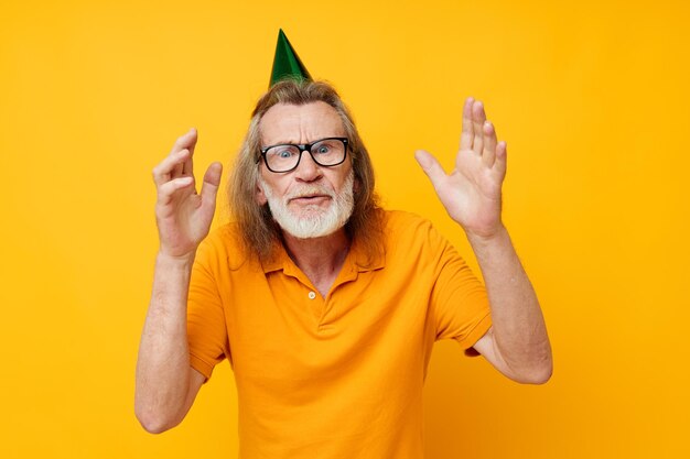 Retrato de homem idoso divertido boné de aniversário no fundo isolado da cabeça