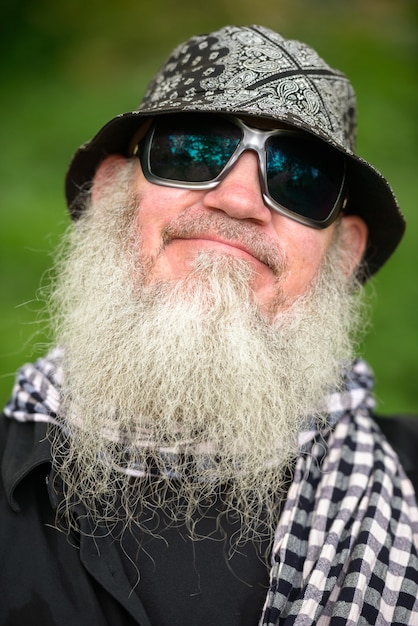 Retrato de homem maduro barbudo hippie no parque ao ar livre