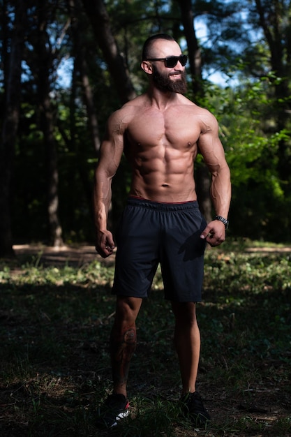 Retrato de homem musculoso em pé forte ao ar livre