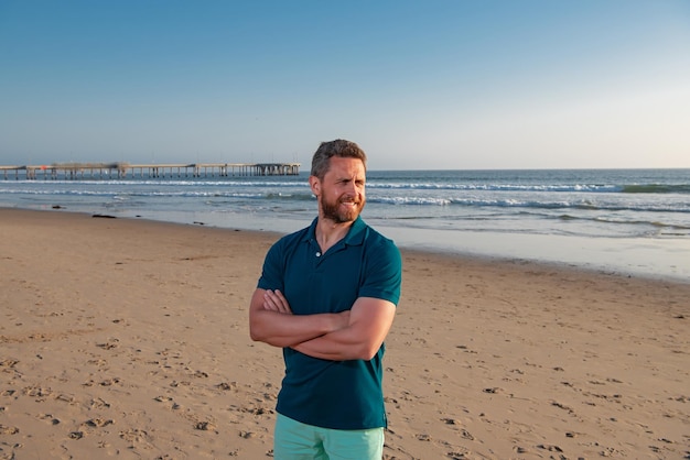 Retrato de homem na praia Retrato ao ar livre de homem bonito posando na praia em bom dia ensolarado vestindo camiseta clássica de tipo casual