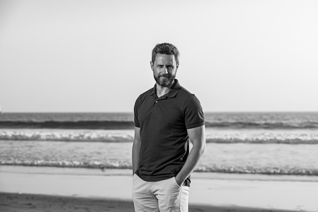 Retrato de homem na praia retrato de homem de meia idade com uma expressão séria e pano de fundo oce...