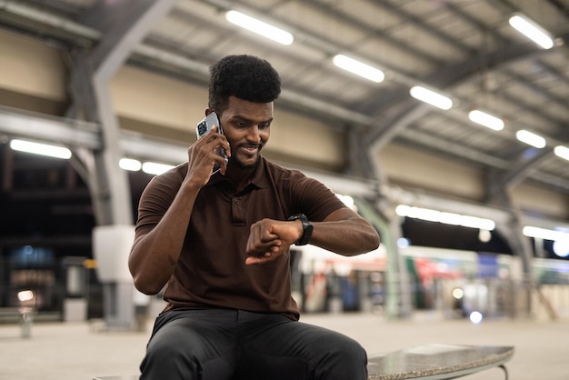 Retrato de homem negro bonito na estação de trem durante a noite