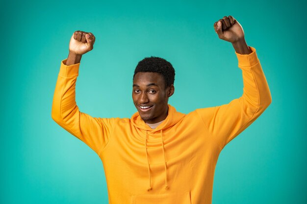 Retrato de homem negro muito feliz comemorando o sucesso no estúdio