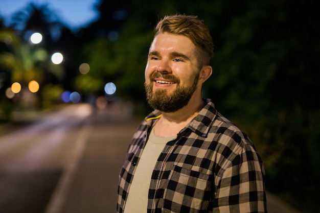 Retrato de homem parado na rua noturna da cidade com espaço para cópia e lugar para texto Cara feliz confiante Retrato aproximado