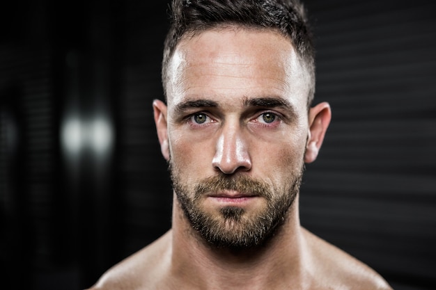 Foto retrato de homem sem camisa, olhando para a câmera no ginásio crossfit